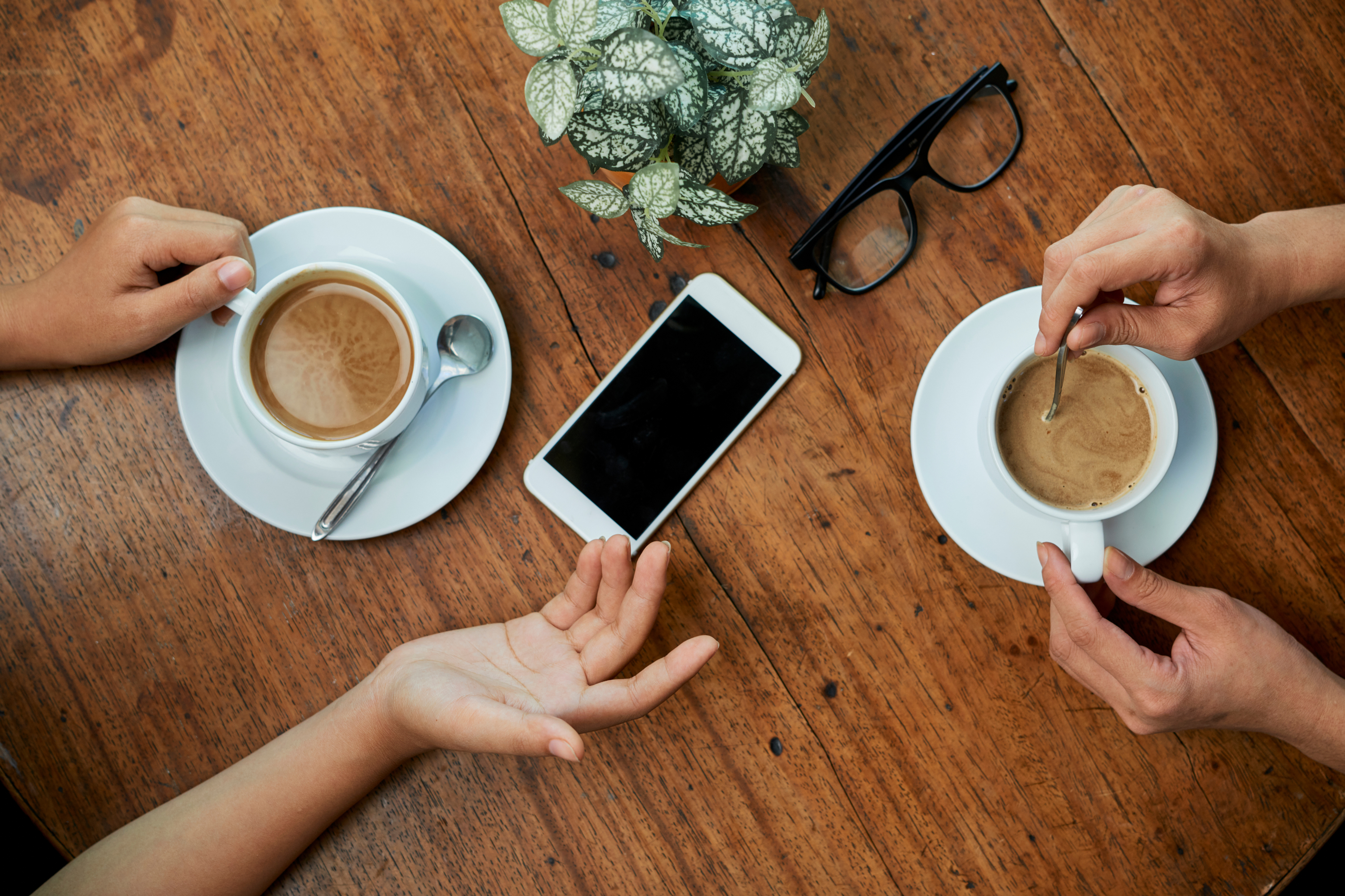 Coffee cups with plant and iPhone